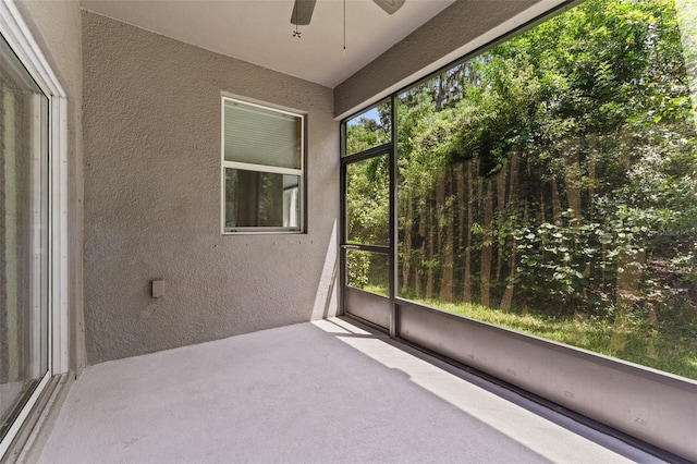 unfurnished sunroom with ceiling fan