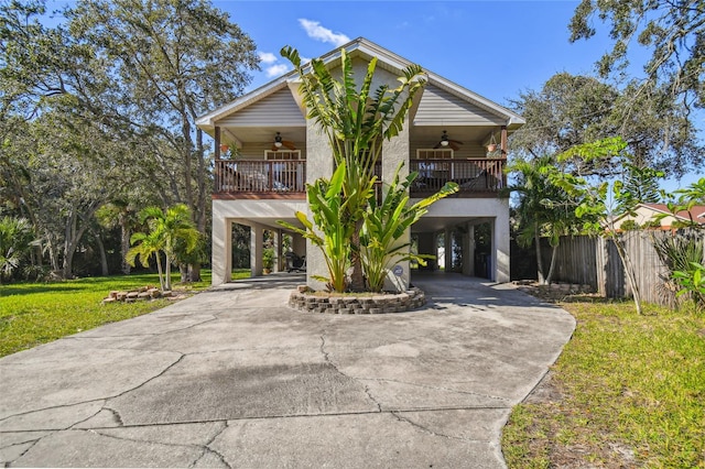 view of front of home featuring ceiling fan, a carport, and a front yard