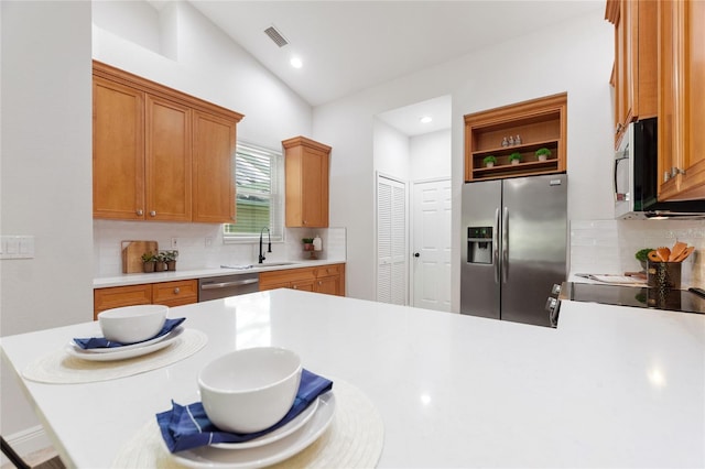 kitchen with sink, tasteful backsplash, appliances with stainless steel finishes, and lofted ceiling