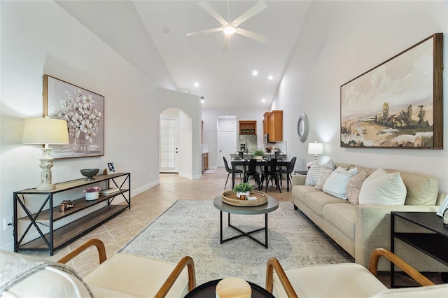 tiled living room featuring ceiling fan and high vaulted ceiling