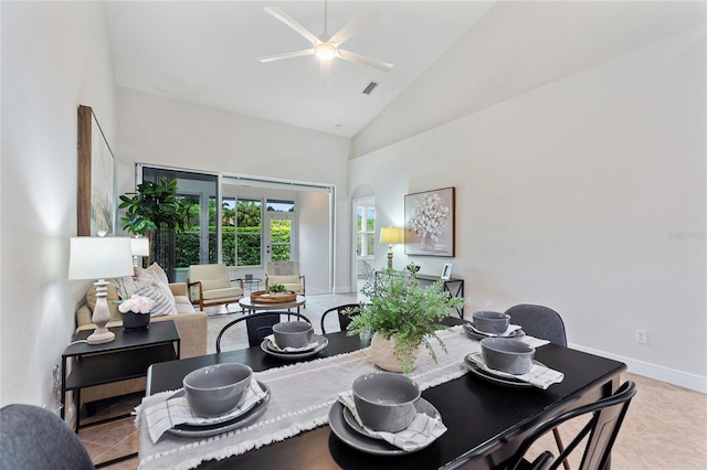 tiled dining room featuring ceiling fan and high vaulted ceiling