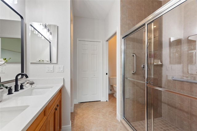 bathroom featuring tile patterned floors, an enclosed shower, vanity, and toilet