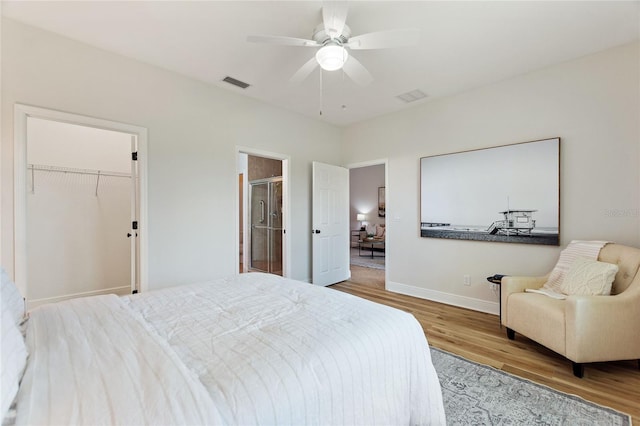 bedroom featuring ceiling fan, a closet, light hardwood / wood-style floors, and a spacious closet