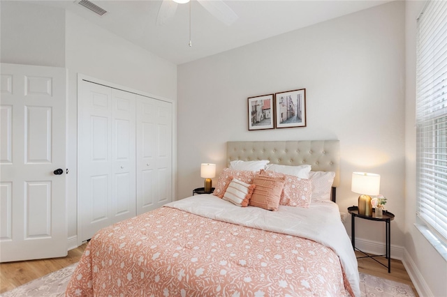 bedroom with light hardwood / wood-style floors, ceiling fan, a closet, and multiple windows