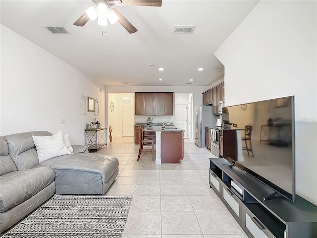 tiled living room with ceiling fan