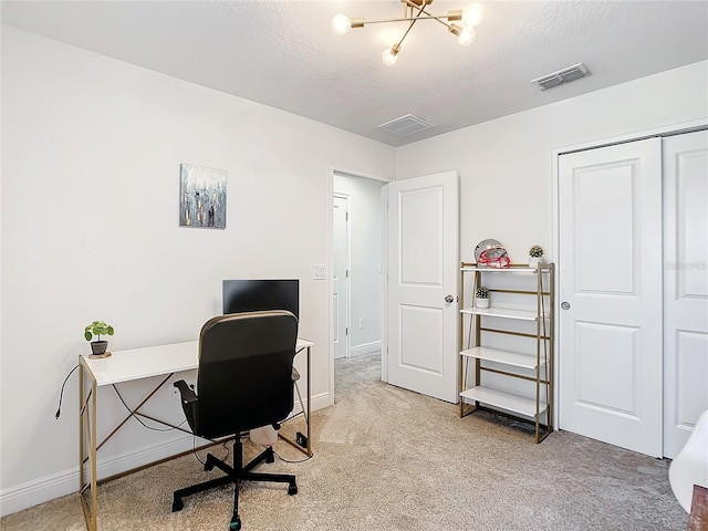 carpeted home office with a textured ceiling and an inviting chandelier