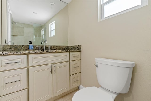 bathroom featuring plenty of natural light, toilet, vanity, and tile patterned floors