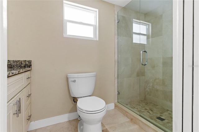 bathroom with tile patterned floors, toilet, a wealth of natural light, and vanity