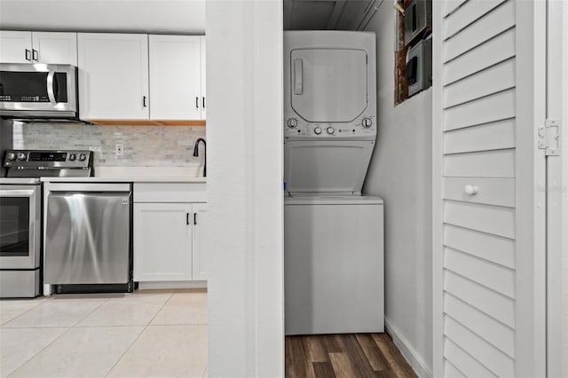 washroom featuring light wood-type flooring and stacked washer and clothes dryer