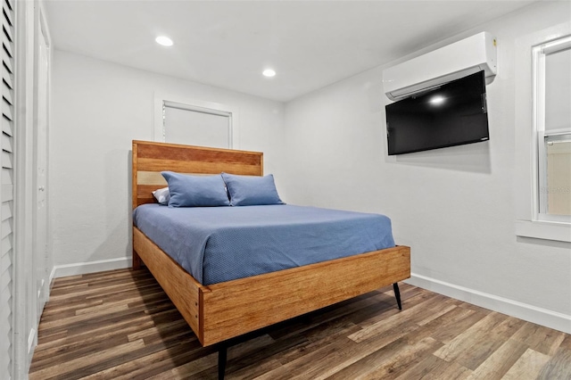 bedroom featuring dark wood-type flooring and a wall mounted AC