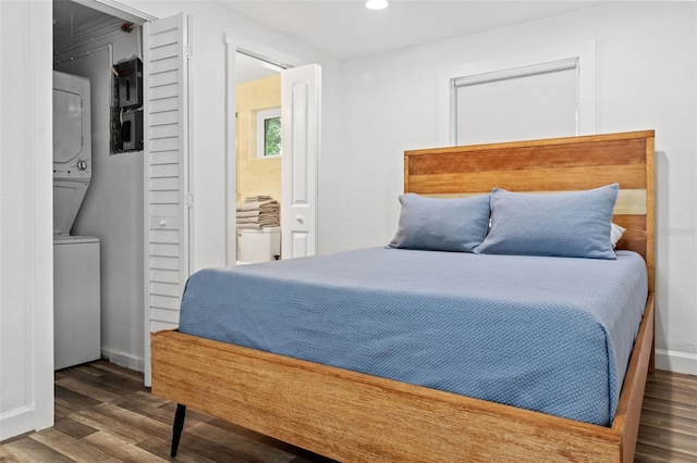 bedroom with stacked washer and clothes dryer, a closet, and wood-type flooring