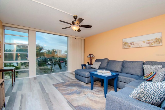 living room featuring floor to ceiling windows, ceiling fan, and wood-type flooring