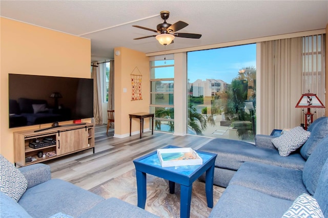 living room featuring ceiling fan and hardwood / wood-style flooring