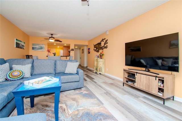 living room featuring hardwood / wood-style floors and ceiling fan