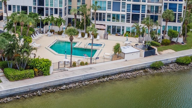 view of swimming pool with a patio area and a water view