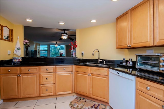 kitchen featuring dishwasher, light tile patterned floors, sink, ceiling fan, and dark stone counters