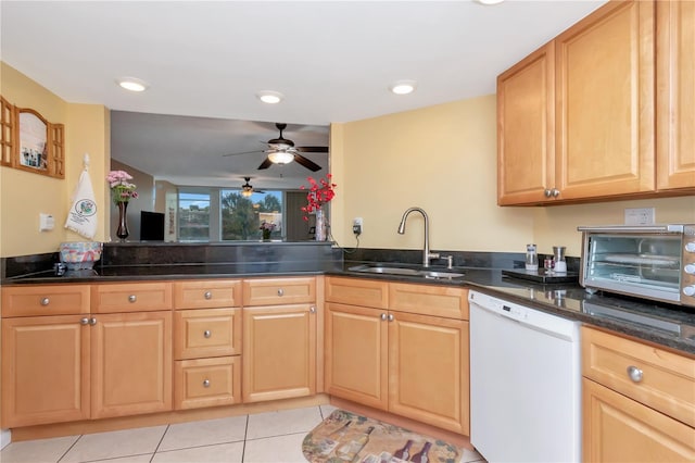 kitchen with dishwasher, sink, kitchen peninsula, and dark stone countertops