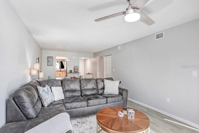 living room with light hardwood / wood-style floors and ceiling fan