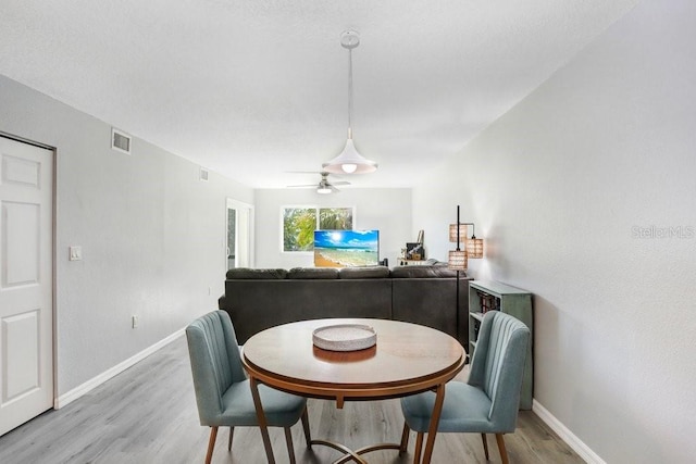 dining space with hardwood / wood-style flooring and ceiling fan