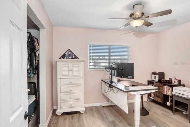 office with light hardwood / wood-style floors and ceiling fan