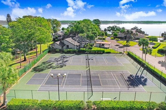 view of tennis court featuring a water view