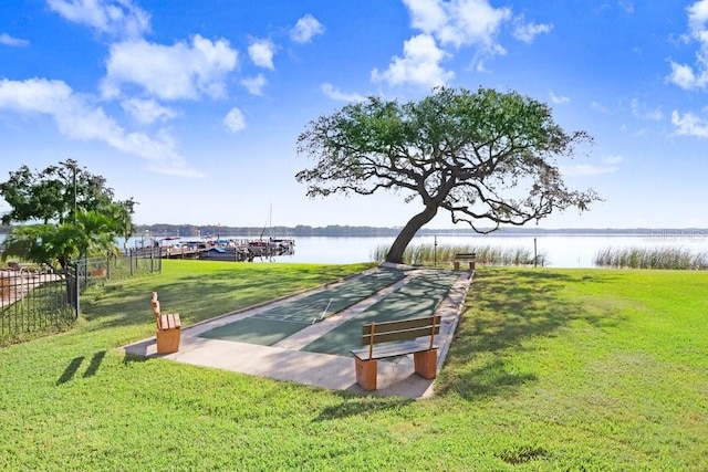 surrounding community featuring a water view and a lawn