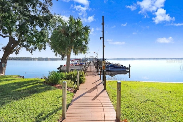 dock area featuring a water view and a lawn