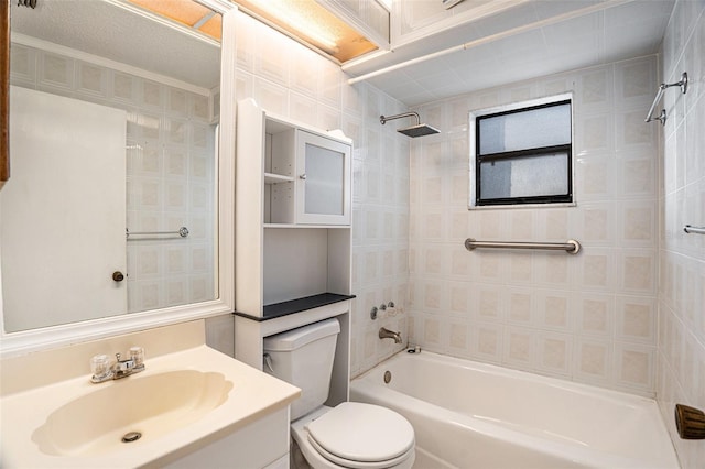 full bathroom with vanity, toilet, a textured ceiling, and tiled shower / bath