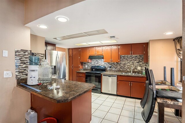 kitchen featuring sink, kitchen peninsula, stainless steel appliances, decorative backsplash, and light tile patterned floors