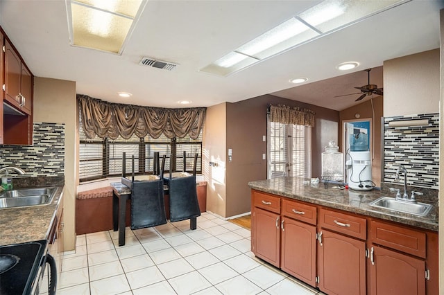 kitchen featuring black electric range, backsplash, lofted ceiling, and sink