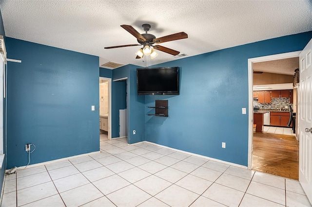 unfurnished bedroom featuring a textured ceiling, light wood-type flooring, and ceiling fan