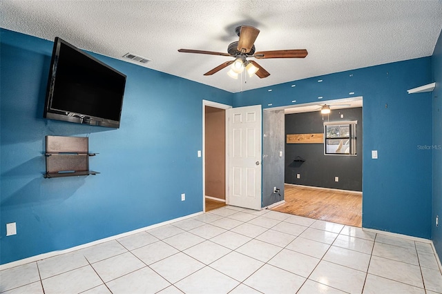 unfurnished room with ceiling fan, a textured ceiling, and wood-type flooring