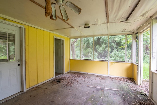 unfurnished sunroom with ceiling fan and plenty of natural light