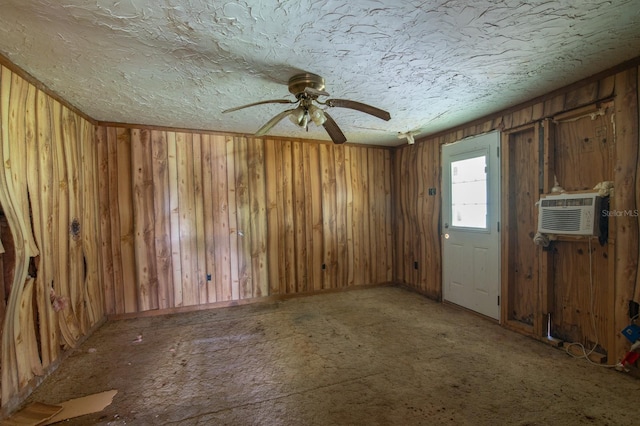 unfurnished room featuring a textured ceiling, ceiling fan, a wall unit AC, and wooden walls