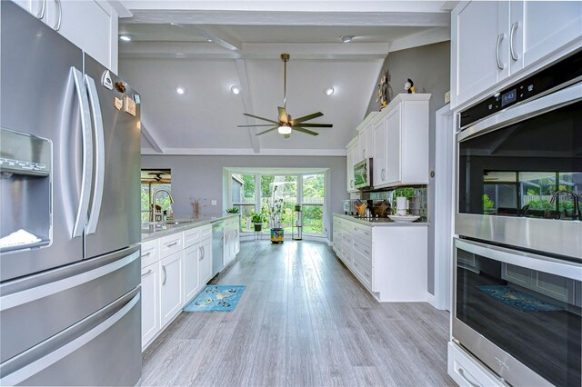 kitchen featuring white cabinets, appliances with stainless steel finishes, lofted ceiling with beams, and ceiling fan