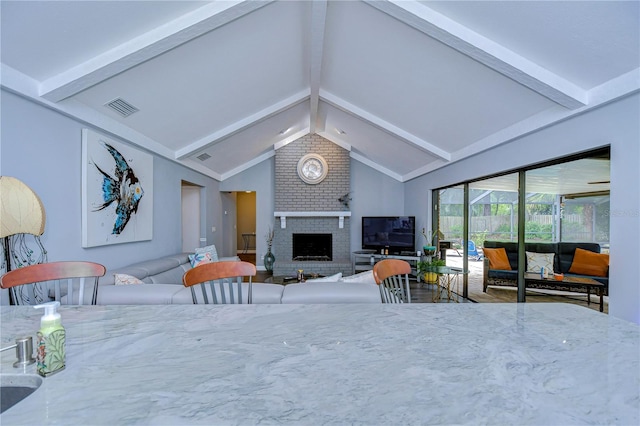 living room featuring high vaulted ceiling, a fireplace, and beam ceiling