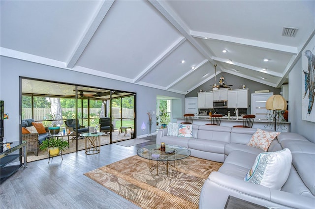 living room featuring beamed ceiling, high vaulted ceiling, and hardwood / wood-style flooring