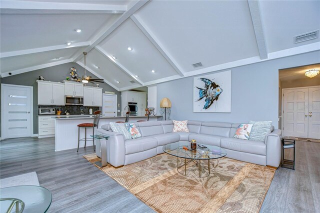 living room featuring light wood-type flooring, ceiling fan, high vaulted ceiling, and beam ceiling