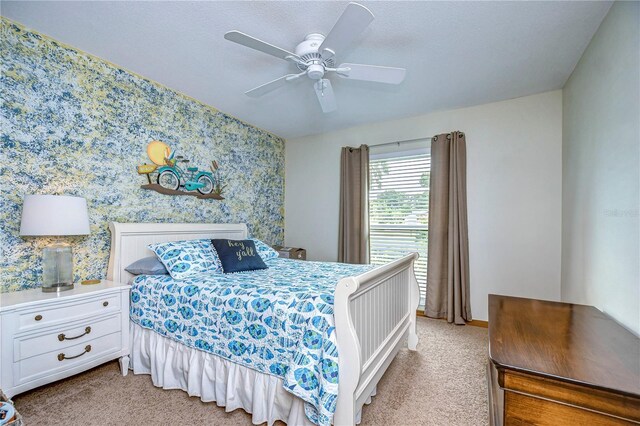 carpeted bedroom featuring ceiling fan and a textured ceiling