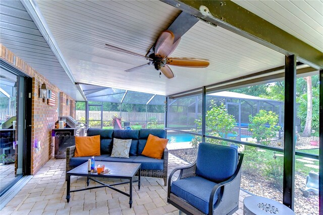 sunroom featuring lofted ceiling, a healthy amount of sunlight, and ceiling fan