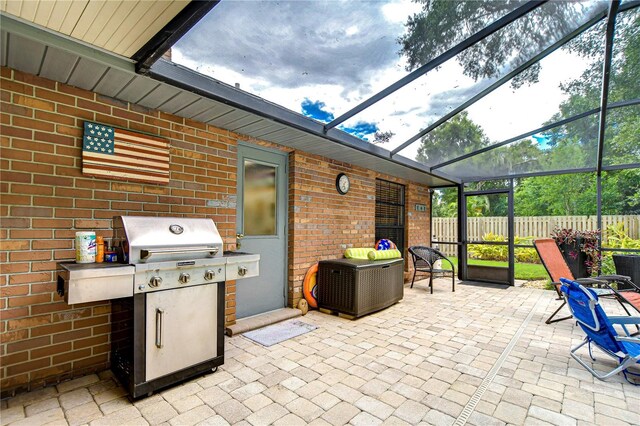 view of patio / terrace featuring glass enclosure and a grill