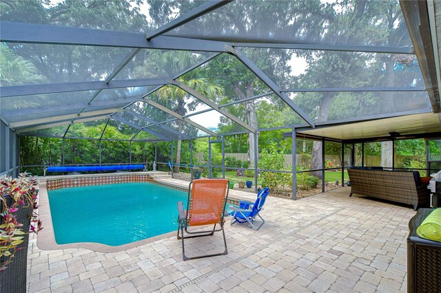 view of pool with glass enclosure and a patio area