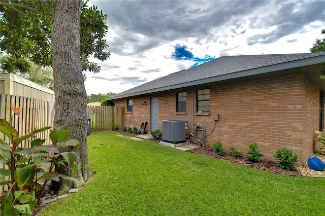 exterior space featuring a lawn and central air condition unit