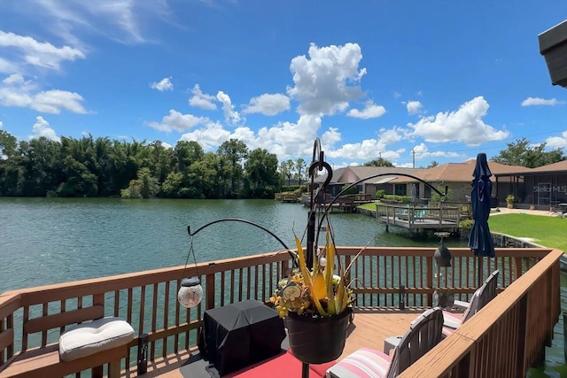 wooden deck featuring a boat dock and a water view