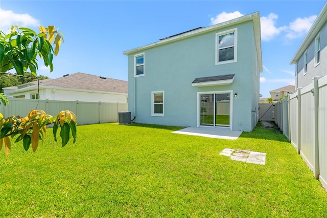 back of property with cooling unit, a patio area, and a yard