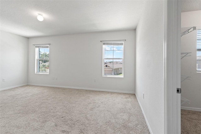 carpeted empty room with a textured ceiling