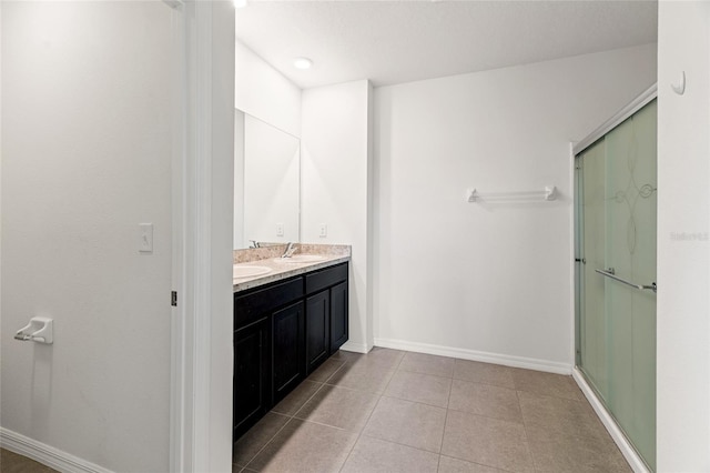 bathroom with tile patterned floors, an enclosed shower, and vanity