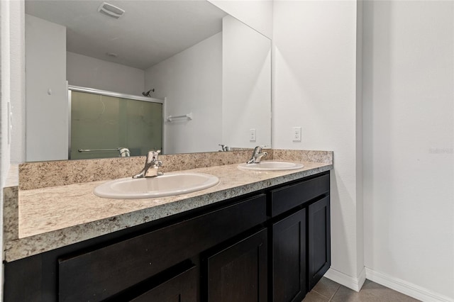 bathroom featuring a shower with door, vanity, and tile patterned floors