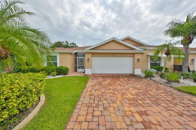 single story home with a front yard and a garage