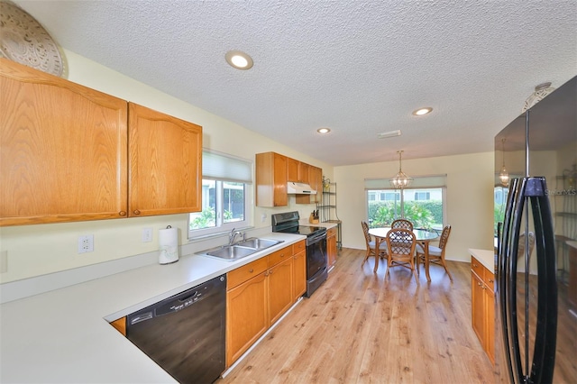 kitchen with sink, plenty of natural light, black appliances, and light hardwood / wood-style floors